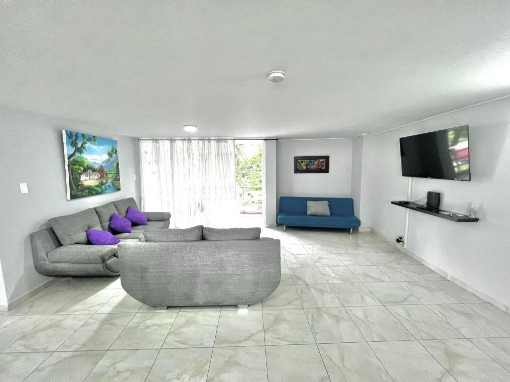 sala de estar con sofá y TV en APARTAMENTO 401 MEDELLIN en Medellín