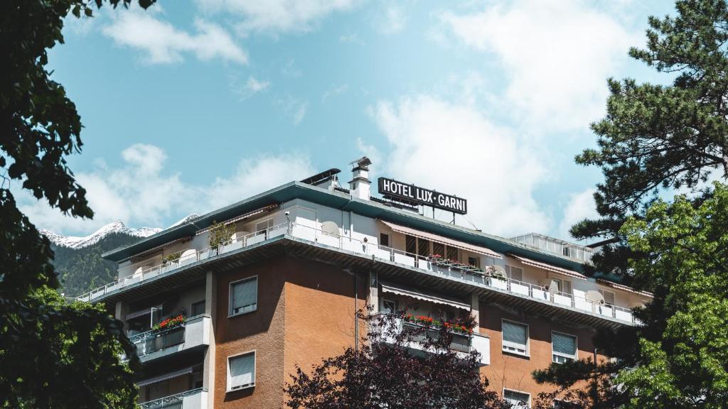 um edifício com um sinal em cima em Hotel Lux em Merano
