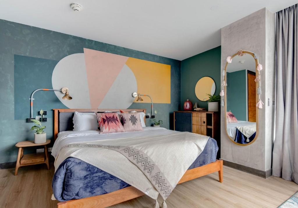 ein Schlafzimmer mit einem großen Bett und einem Spiegel in der Unterkunft Selina Parque 93 Bogota in Bogotá