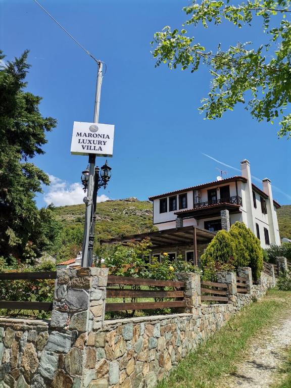 a sign on a stone wall in front of a house at Maronia Luxury Villa in Maronia