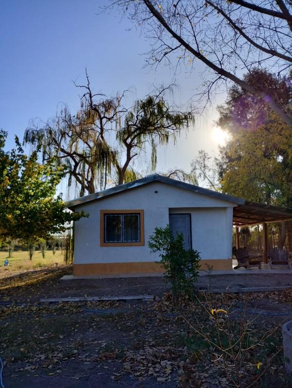 una pequeña casa blanca con árboles en el fondo en El RANCHO en San Martín