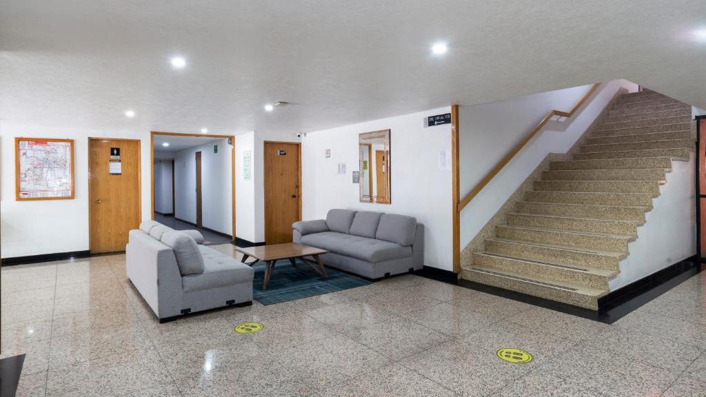 A corridor lounge with two sofas and a coffee table beside a broad staircase.