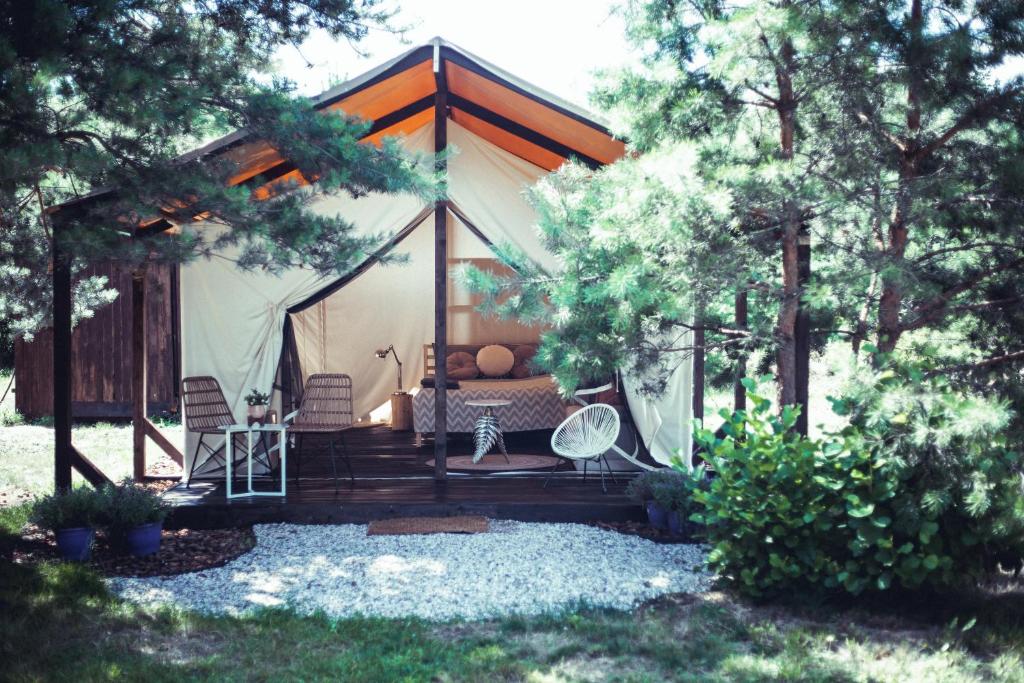 ein Zelt mit einem Bett und Stühlen im Hof in der Unterkunft Boho Park Glamping in Zawiszyn