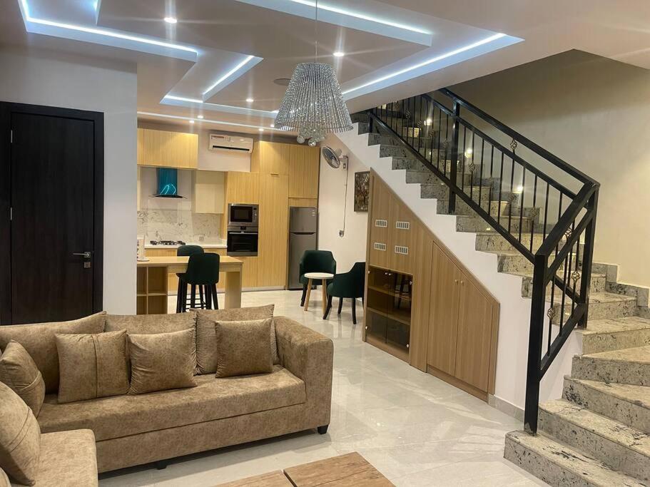 sala de estar con sofá y escalera en Urban Haven - Surulere, en Lagos