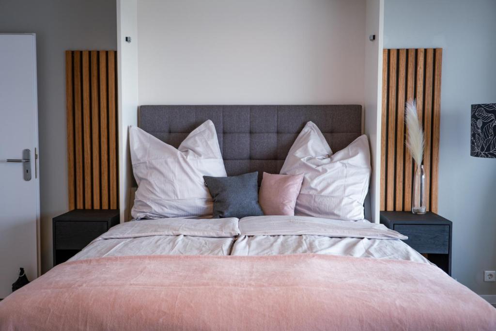 a bedroom with a large bed with many pillows at Golden Hour Apartment Wangerooge in Wangerooge