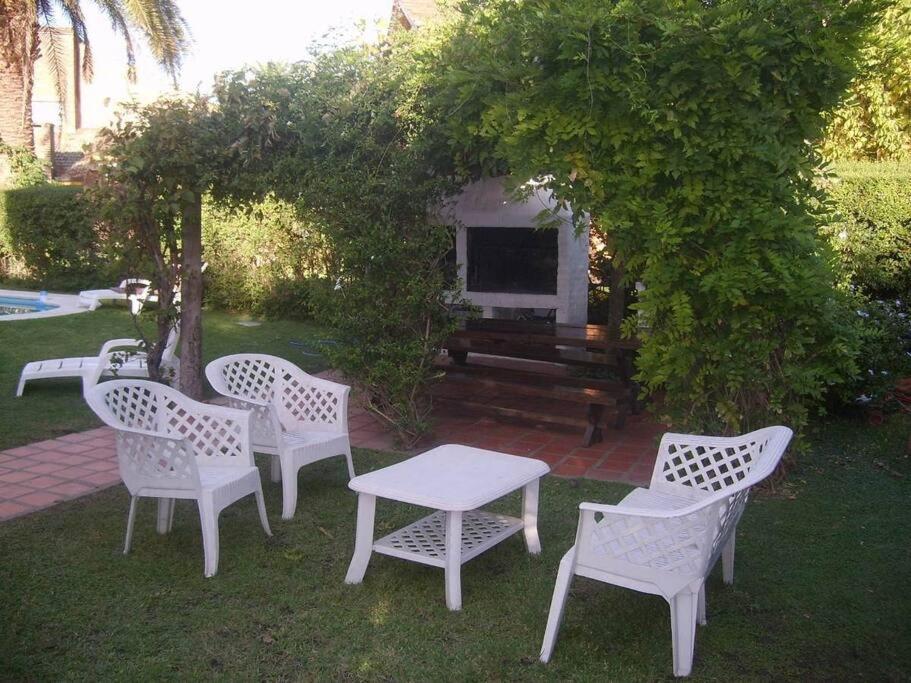 un groupe de chaises et de tables blanches dans une cour dans l'établissement club de campo los horneros, à Ingeniero Maschwitz