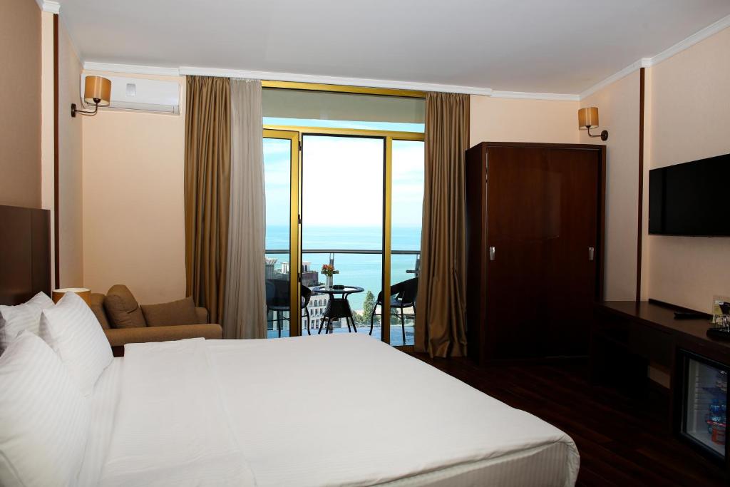 a hotel room with a bed and a large window at Hotel Corner Inn in Batumi