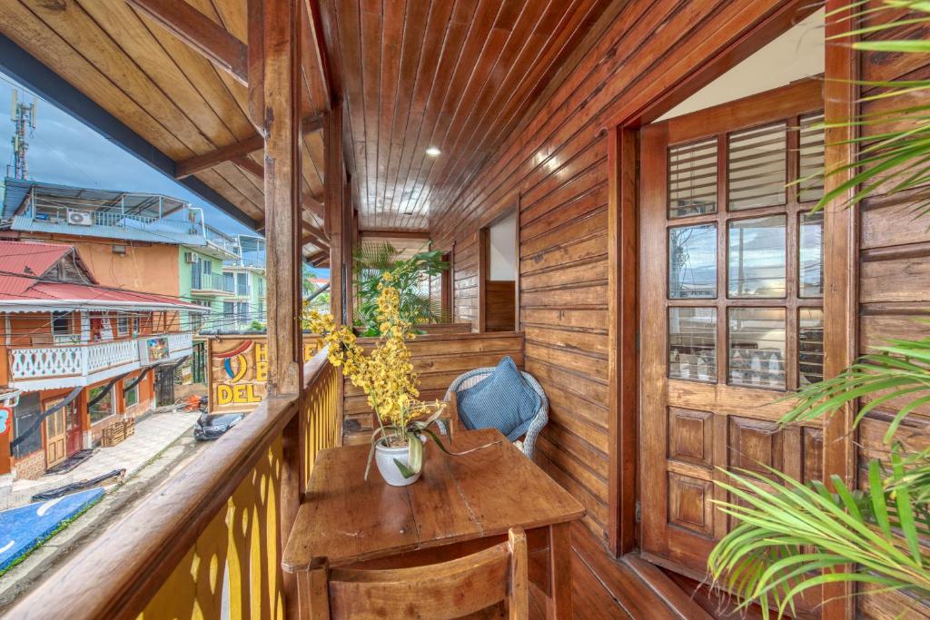 a balcony with wooden walls and a table with plants at Hotel Bocas del Toro in Bocas del Toro