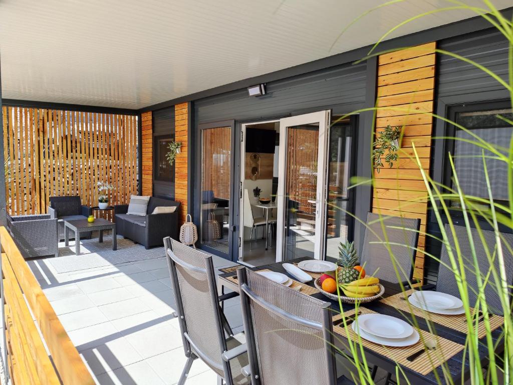 un patio con mesa y sillas en una terraza en ARIA Mobile Home, Oaza Mira 5 Star Camping, Dalmatia en Drage