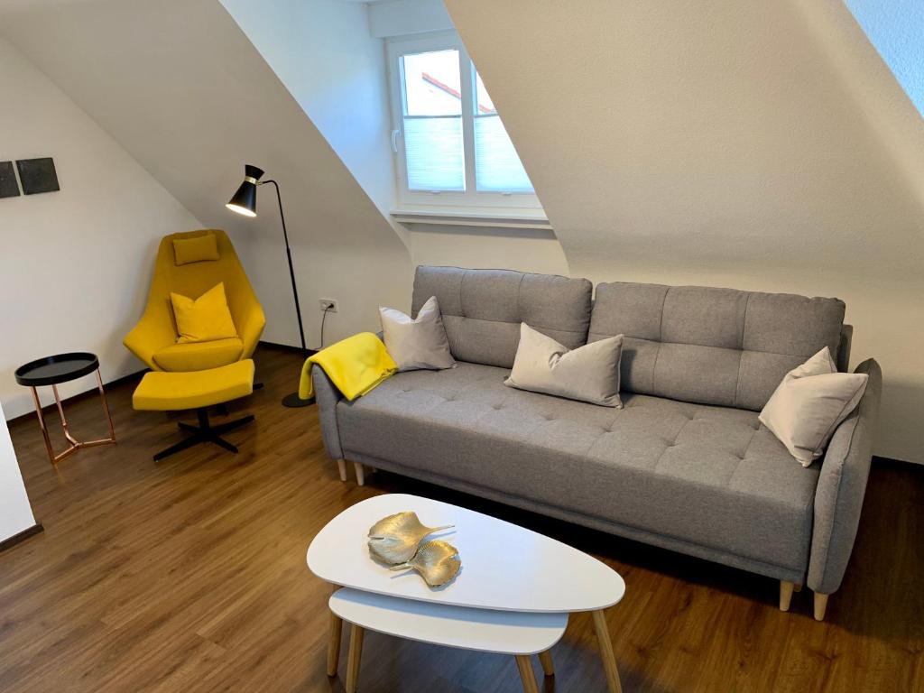 a living room with a couch and a yellow chair at Apartment im alten Rathaus in Malterdingen