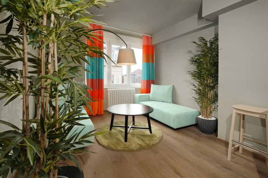 ein Wohnzimmer mit einem grünen Sofa und einem Tisch in der Unterkunft Tulum Apart Center Belgrade in Belgrad