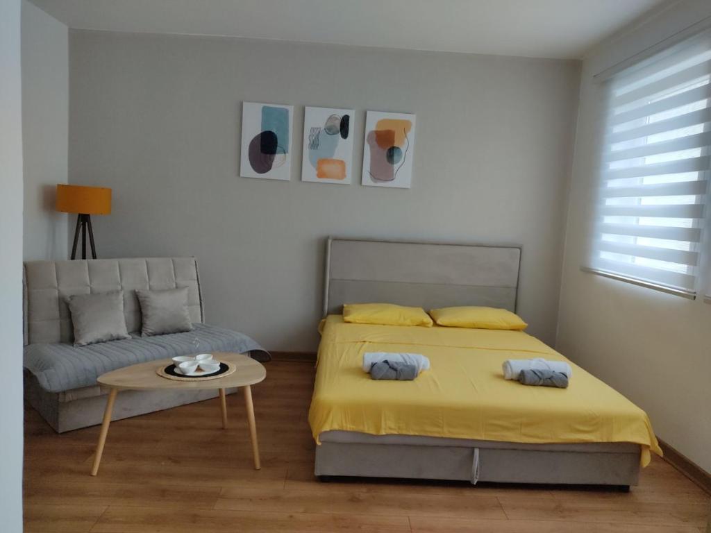 ein Schlafzimmer mit einem Bett, einem Tisch und einem Sofa in der Unterkunft Apartman Andjela in Plužine