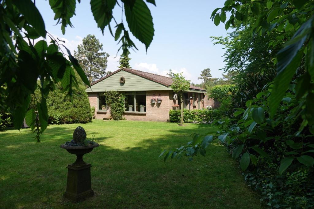 ein Haus mit einem Garten mit einer Statue im Hof in der Unterkunft Hof van Benten in Ermelo