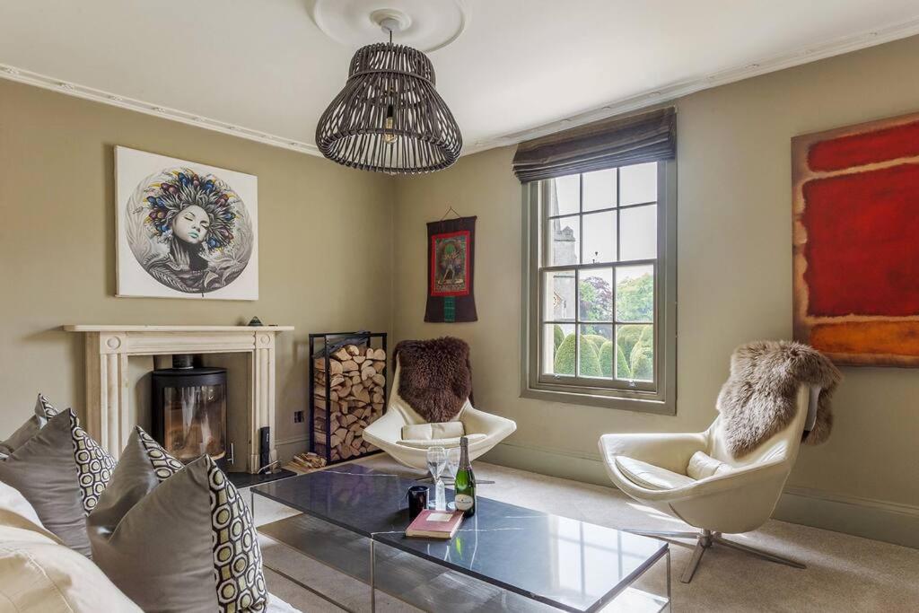 a living room with a glass table and two chairs at A beautiful Georgian town house in Painswick in Painswick