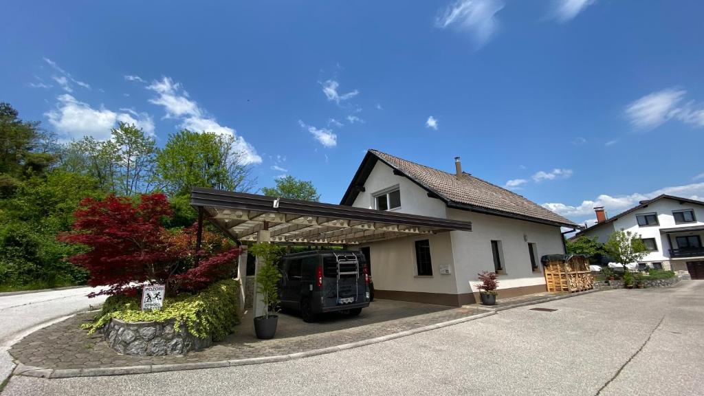 uma casa com um carro estacionado na entrada em Apartma Nomad em Novo Mesto