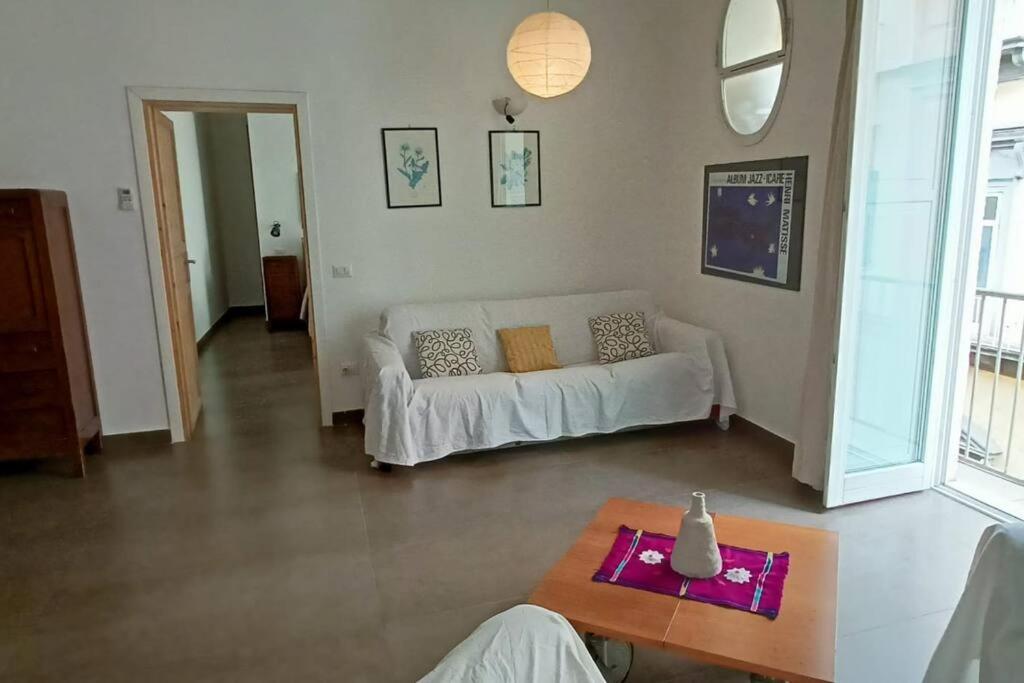 un soggiorno con divano bianco e tavolo di Appartamento - Casa Madre a Napoli