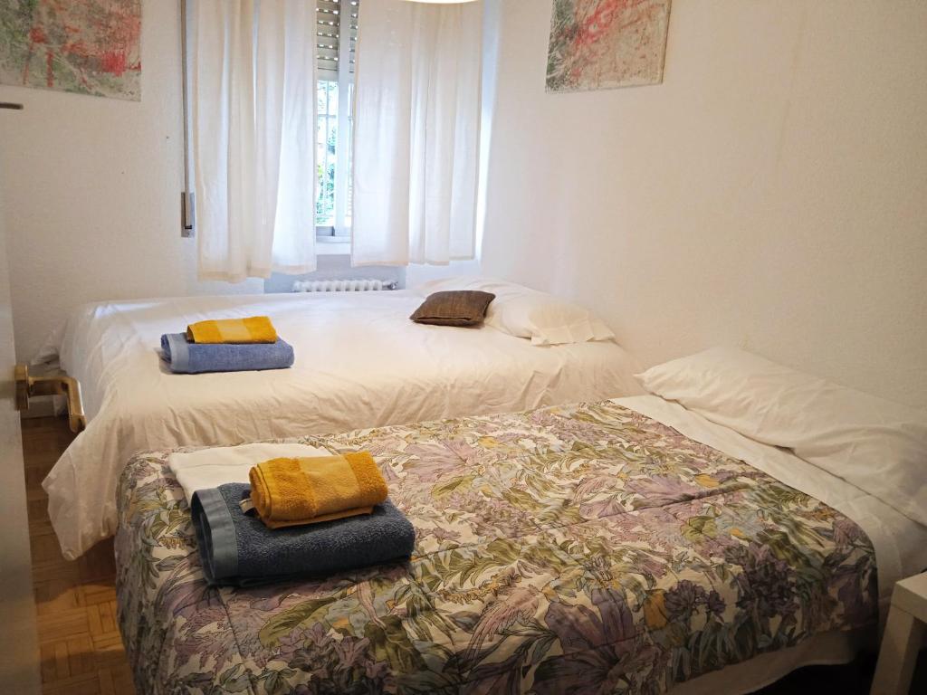 two beds sitting next to each other in a room at Apartamento a 15 minutos del centro in Madrid