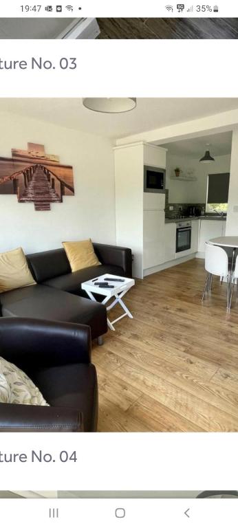 a living room with a couch and a table at Sunny49 min 3 night stay in Caeathro