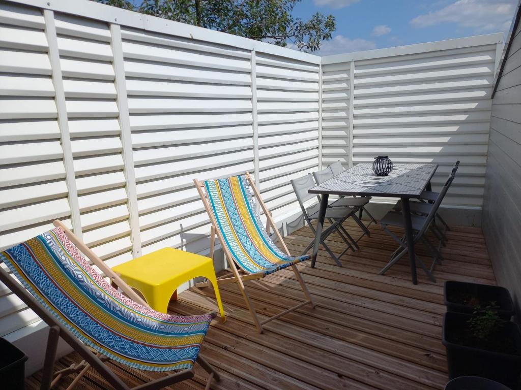un patio avec une table et des chaises sur une terrasse dans l'établissement La Maison bleue des Mathes, aux Mathes