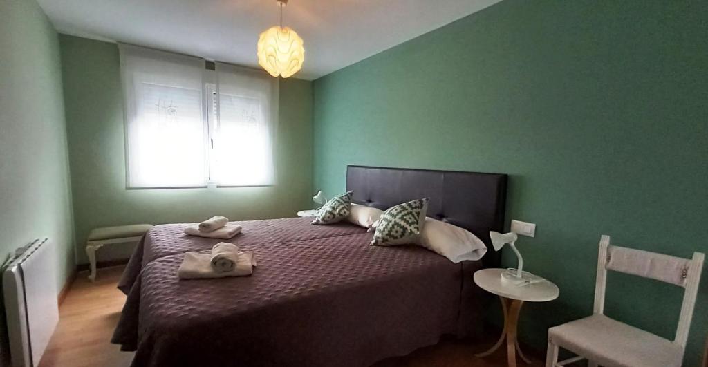 アルスーアにあるCastelao Apartmentsの緑のベッドルーム(タオル付きのベッド付)