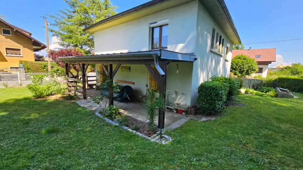 a white house with a porch on a yard at Villa La Moraine in Thonon-les-Bains