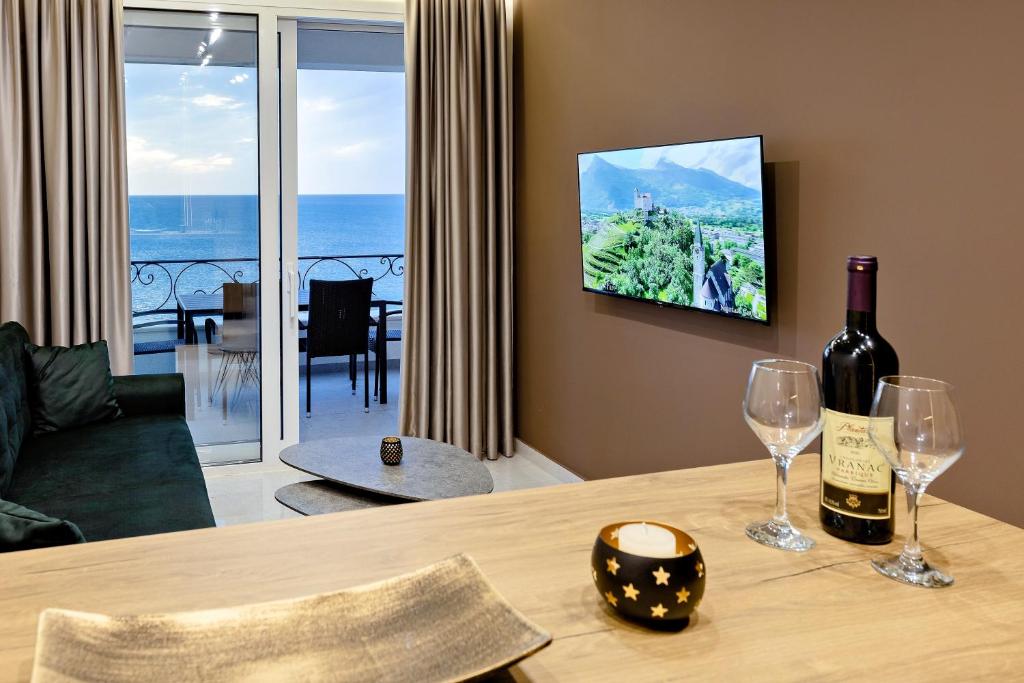 een woonkamer met een tafel met twee wijnglazen bij Apartments Piano in Utjeha