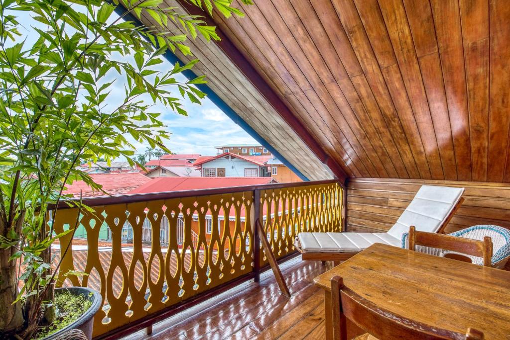 a porch with a table and chairs on a balcony at Hotel Bocas del Toro in Bocas del Toro
