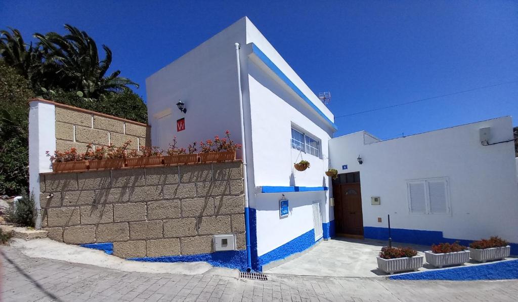 CASA ISABEL - (ZONA RURAL) في Fasnia: مبنى ابيض وزرق بجدار وباب