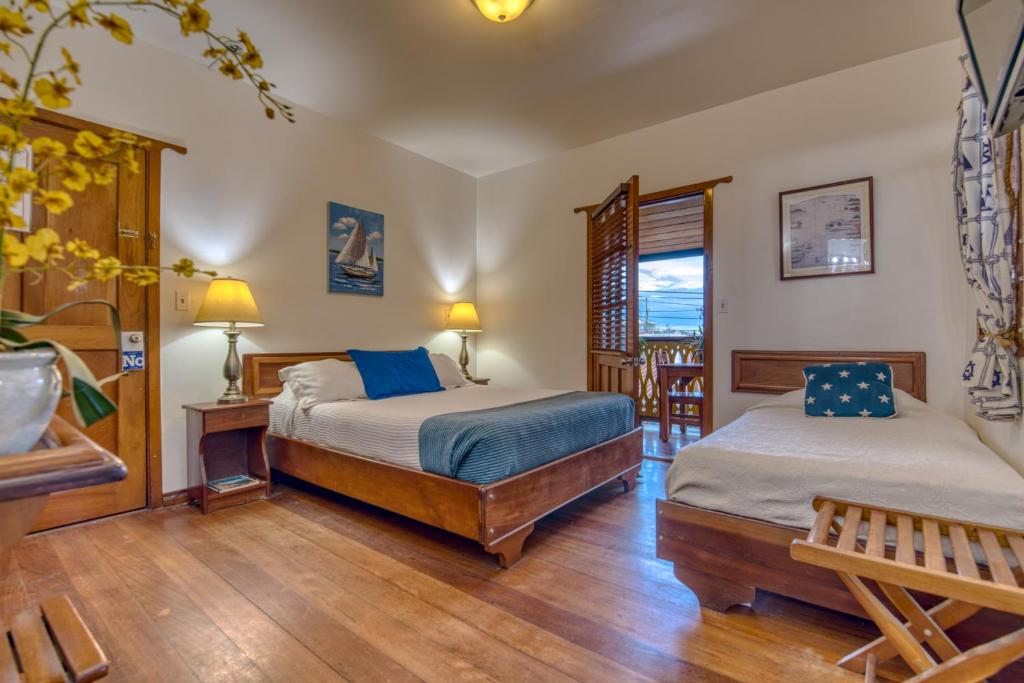 a bedroom with two beds and a wooden floor at Hotel Bocas del Toro in Bocas del Toro