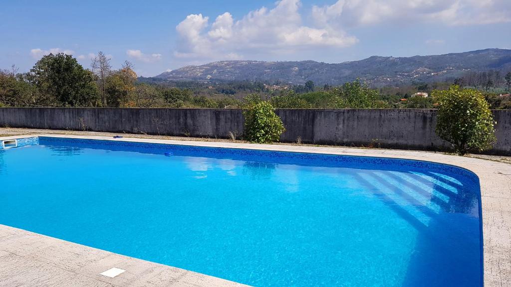 a large blue swimming pool with mountains in the background at Lugar de Levides 