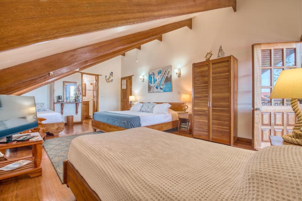 a hotel room with two beds and a television at Hotel Bocas del Toro in Bocas del Toro