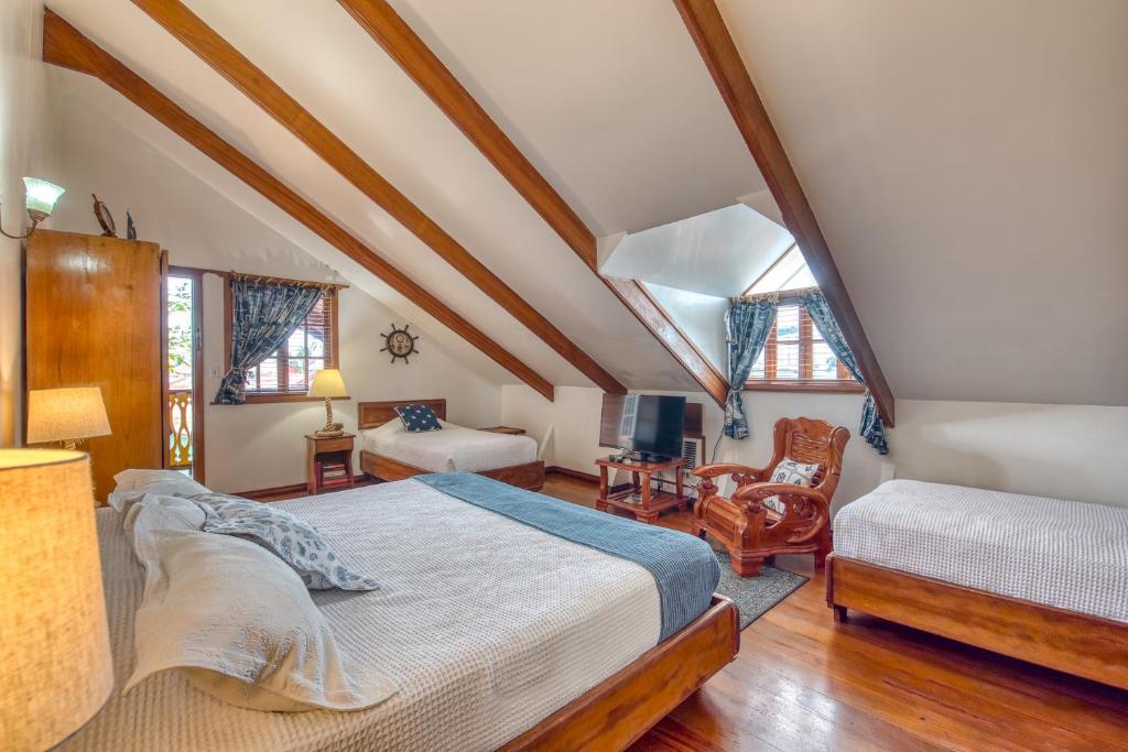 a attic bedroom with a bed and a chair at Hotel Bocas del Toro in Bocas del Toro