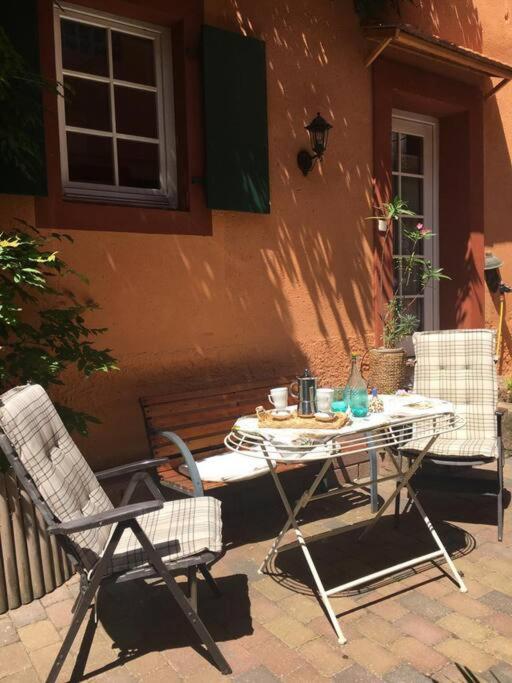 a table and chairs sitting outside of a building at Ferienhaus im Haus der Künste in Rhodt unter Rietburg
