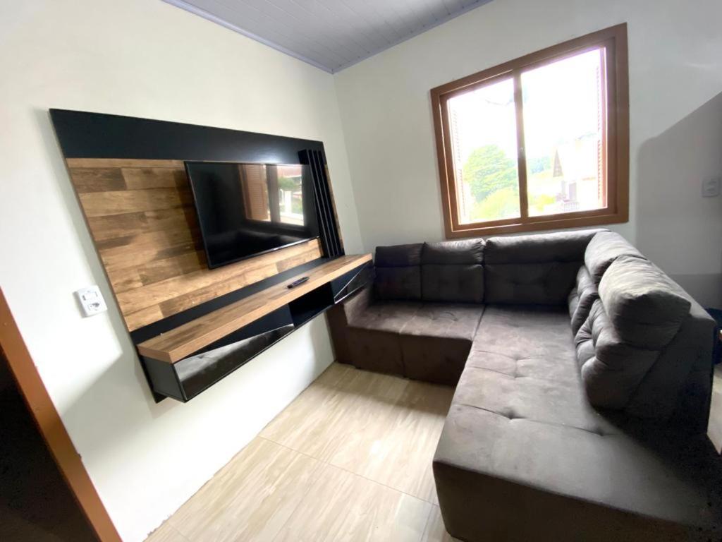 a living room with a couch and a flat screen tv at Sobrado Toledo in São Francisco de Paula