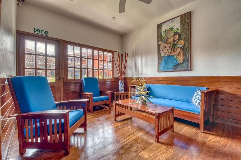 a living room with blue furniture and a painting on the wall at Hotel Bocas del Toro in Bocas del Toro