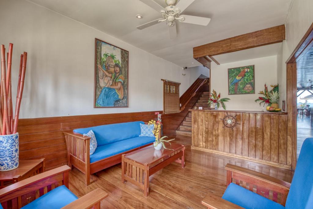 a living room with a blue couch and wooden floors at Hotel Bocas del Toro in Bocas del Toro