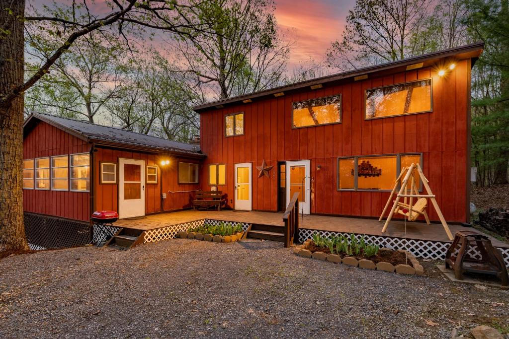 eine rote Scheune mit einer Veranda und einem Haus in der Unterkunft Relaxing 2-Master Suite Mountain Top - Fire Pit in New Market