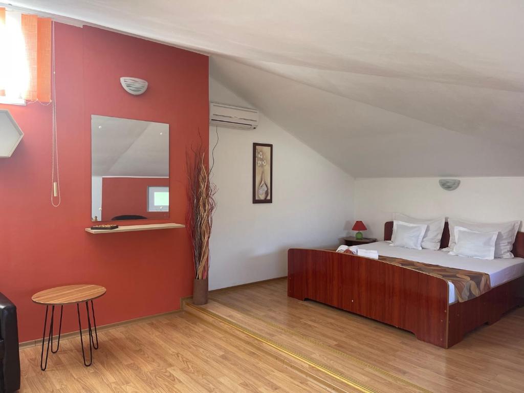 a bedroom with a bed and a red wall at Casa Constantin si Elena ( Adults only ) in Eforie Nord