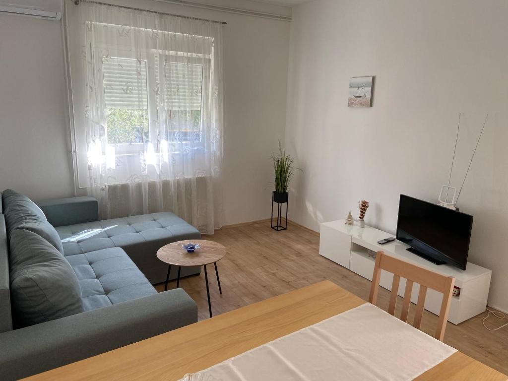 sala de estar con sofá y TV en Apartmani Gojko, en Biograd na Moru