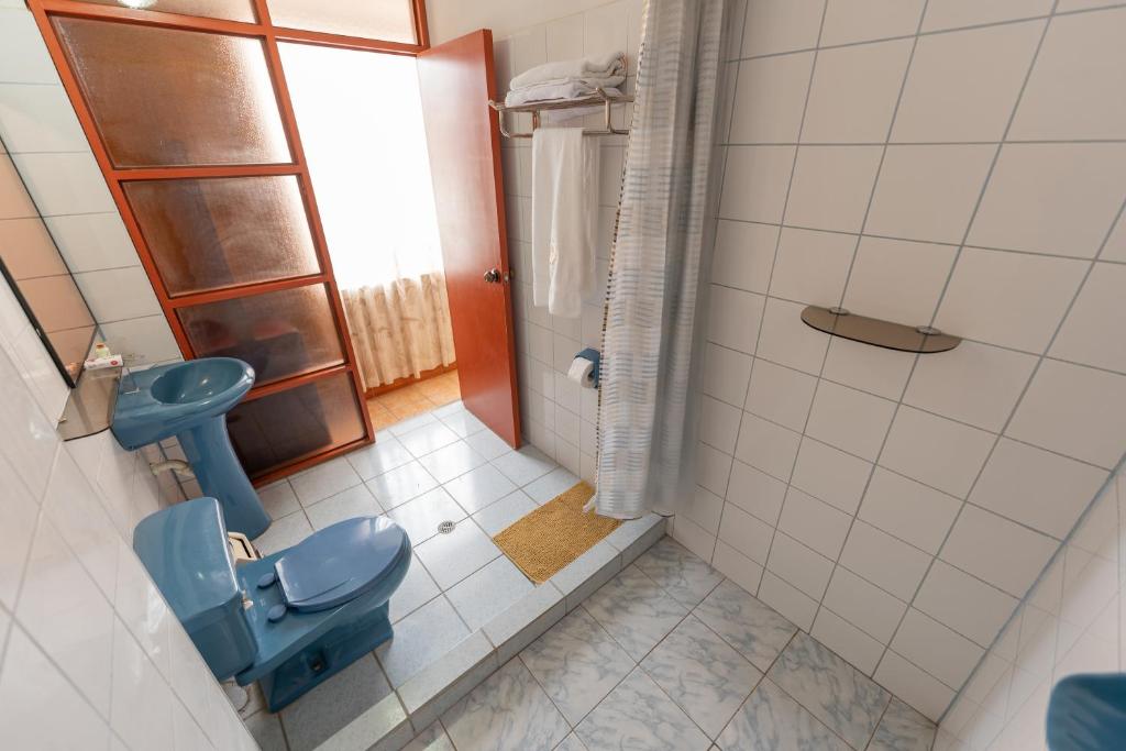 bagno con servizi igienici blu e lavandino di Huanuco Pampa Suite a Huánuco