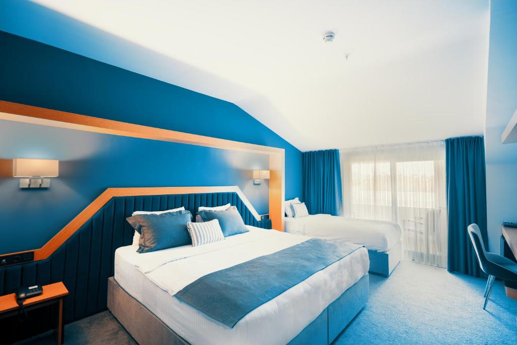 um quarto de hotel com uma cama e uma parede azul em Roof 264 Hotel & Suites em Sakarya