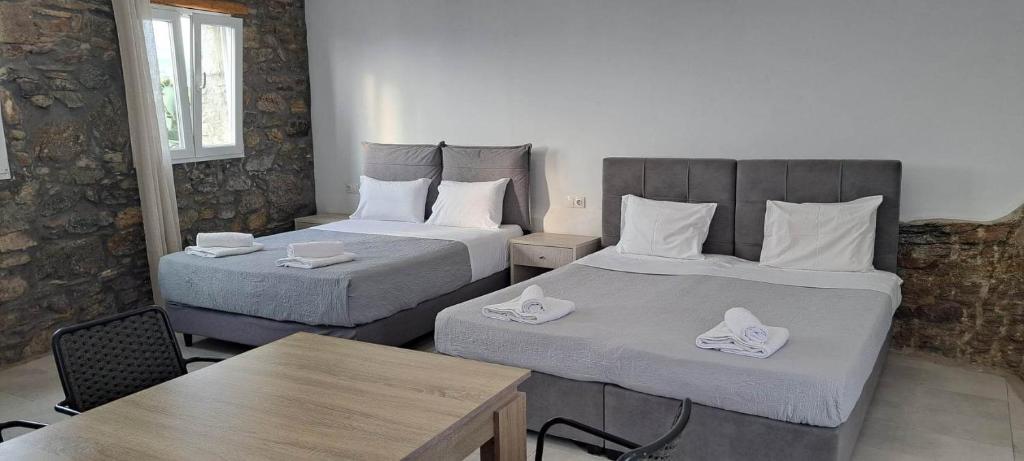 a hotel room with two beds and a table at Fabrica Sunset Apartments in Megali Ammos
