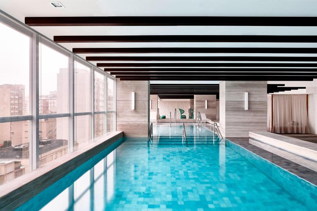 a swimming pool in a building with windows at Sheraton Santos Hotel in Santos