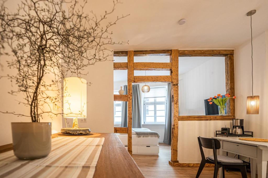 a kitchen and living room with a table and a mirror at Klein aber Fein in Weinheim