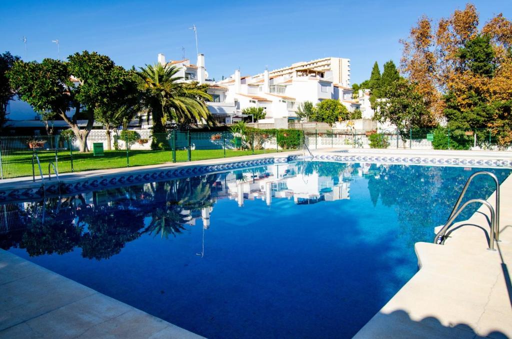 basen z błękitną wodą i budynki w tle w obiekcie Mar del Sur Bonito w mieście Benalmádena
