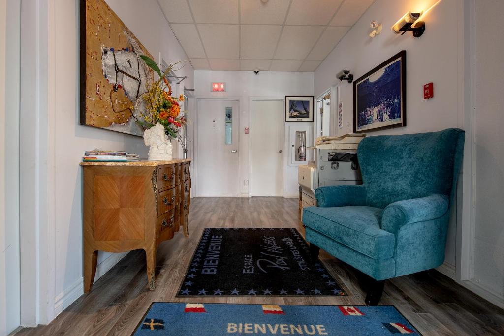 a living room with a blue chair and a table at Auberge Internationale Espace Globetrotter in Rimouski