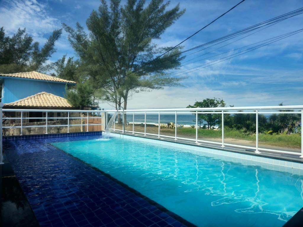 a swimming pool with a view of the ocean at Pousada Viva Mar in Saquarema