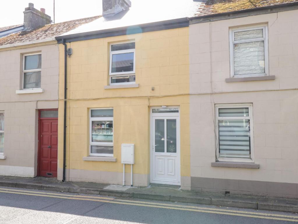 una casa gialla con una porta rossa su una strada di 22 Town Place a Ballinrobe