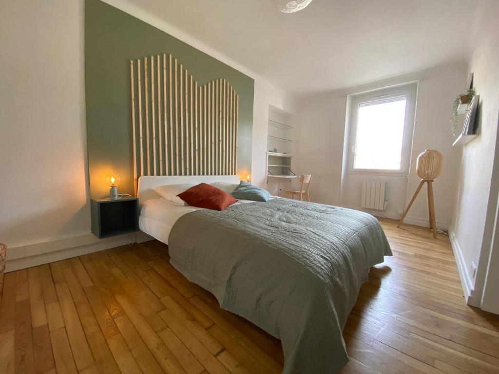 Un dormitorio con una cama grande y una ventana en L'appart du cœur de bourg, en Guéméné-Penfao