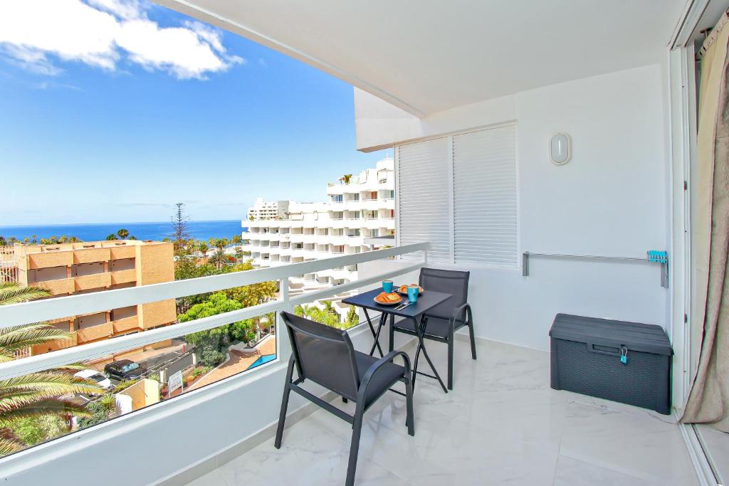 a balcony with a table and chairs and the ocean at Buena Vista Ponderosa 517 in Playa Fañabe
